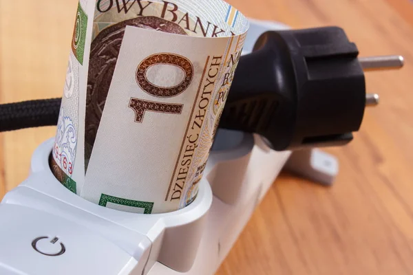 Rolls of polish currency money in electrical power strip and disconnected plug, energy costs — Stock Photo, Image