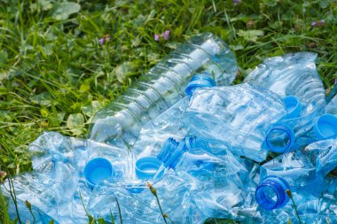 Plastik şişe ve şişe kapakları Park, çimlerin üzerine çevre çöp