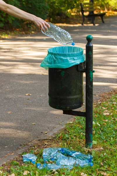 Ruka ženy házet láhve do recyklace bin, odhazování životního prostředí — Stock fotografie