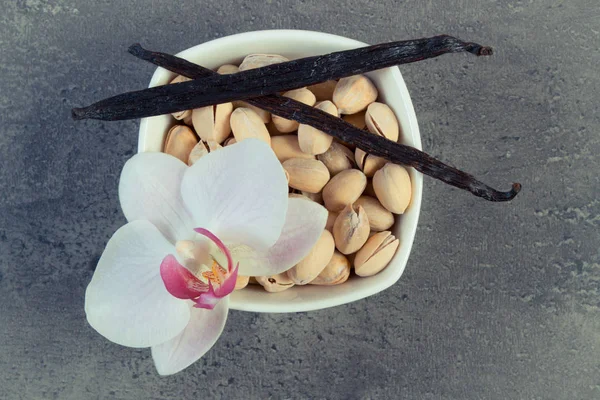 Foto vintage, Nozes de pistache, orquídea florescente e palitos de baunilha perfumados, ingredientes cosméticos — Fotografia de Stock