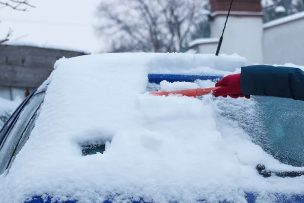 Mano della donna con pennello e rimuovere la neve da auto e parabrezza — Foto Stock