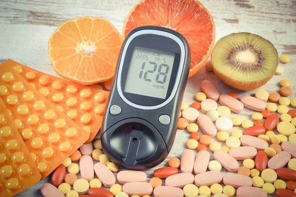 Jahrgangsfoto, Glukometer mit Ergebnis, Früchte und bunte Pillen, Diabetes, gesunder Lebensstil und Ernährung — Stockfoto