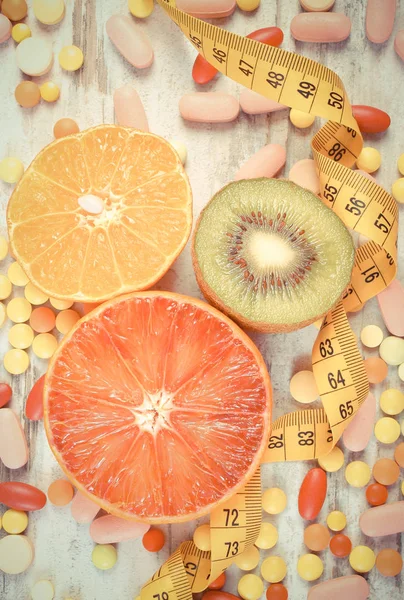 Foto vintage, Frutas naturales, centímetros y píldoras médicas, adelgazamiento, elección entre la nutrición saludable y suplementos médicos — Foto de Stock