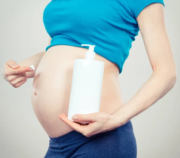 Foto vintage, Mujer embarazada aplicando loción hidratante en el vientre, evitar las estrías — Foto de Stock