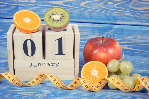 Calendário de cubo, frutas e fita métrica, resoluções de anos novos — Fotografia de Stock