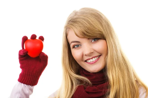 Mulher em luvas de lã segurando coração vermelho, símbolo do amor — Fotografia de Stock