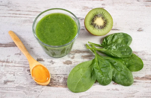 Ispanak ve eski ahşap zemin, sağlıklı beslenme üzerine bal ile kivi kokteyl