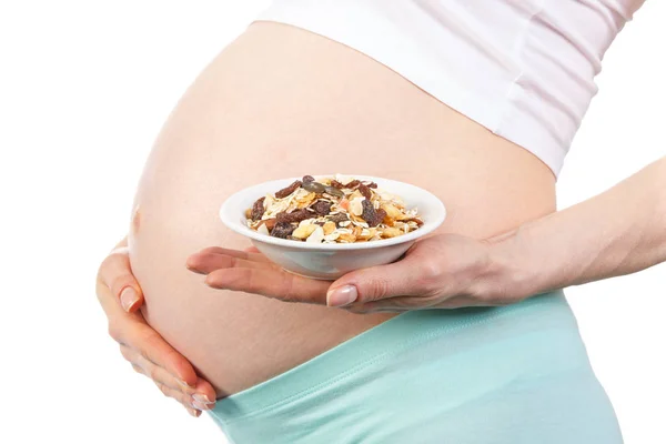 Беременная женщина с хрустящим мюсли в миске, здоровое питание во время беременности — стоковое фото