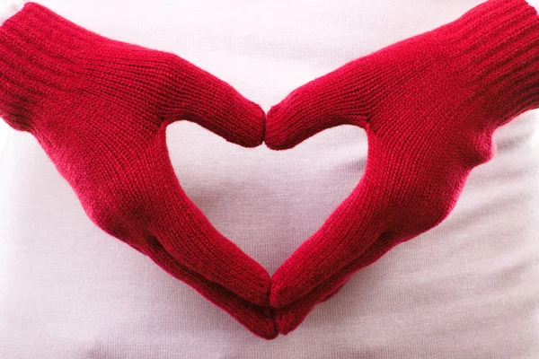 Mano en guantes de lana dispuestos en forma de corazón, símbolo del amor — Foto de Stock