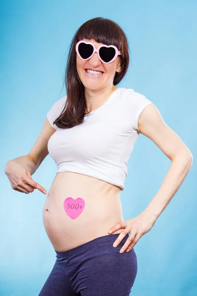 Zwangere vrouw kaart met inscriptie 500 +, sociaal programma en beleid in Polen tonen — Stockfoto
