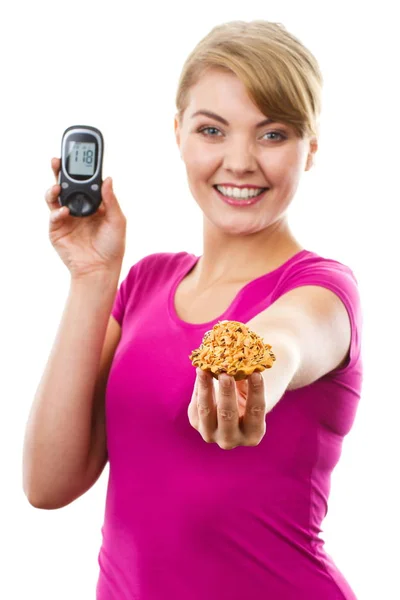 Glückliche Frau mit Glukometer und frischem Cupcake, Messung und Kontrolle des Zuckerspiegels, Konzept Diabetes — Stockfoto
