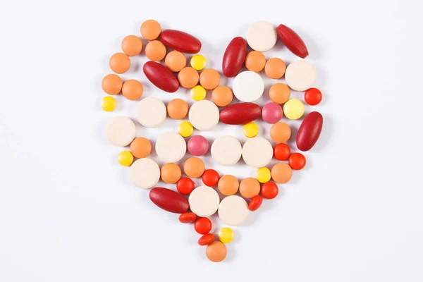 Pilules et capsules médicales en forme de coeur sur fond blanc, concept de soins de santé — Photo