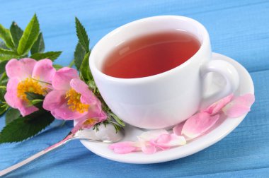 Fincan çay ve mavi kurullarında yabani gül çiçek