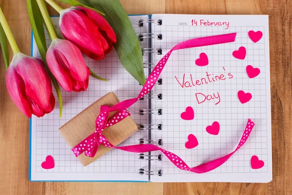 San Valentino scritto in taccuino, tulipani freschi, regalo avvolto e cuori, decorazione per San Valentino — Foto Stock