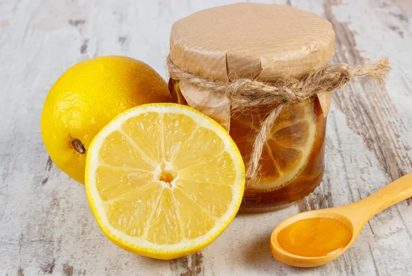 Limón fresco y miel sobre mesa de madera, nutrición saludable — Foto de Stock