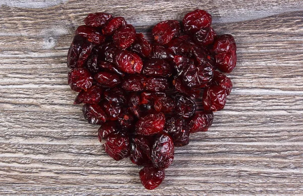 木制的桌子上的红色小红莓的心 — 图库照片