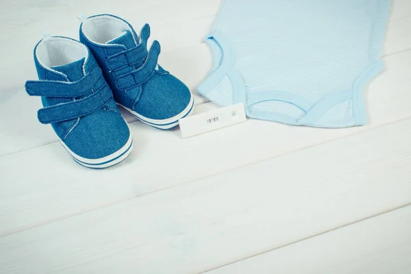 Foto vintage, teste de gravidez com resultado positivo e roupas para recém-nascido, esperando para o bebê — Fotografia de Stock