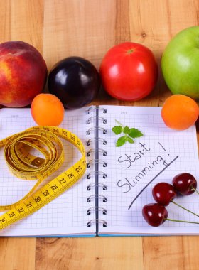 Meyve, sebze ve santimetre ile defter, zayıflama ve sağlıklı gıda