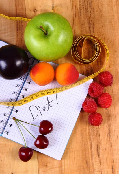 Fruits et centimètre avec carnet, minceur et aliments sains — Photo