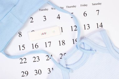 Hamilelik testi pozitif sonuç ve bebek için bekliyor takvimde yeni doğan için giyim