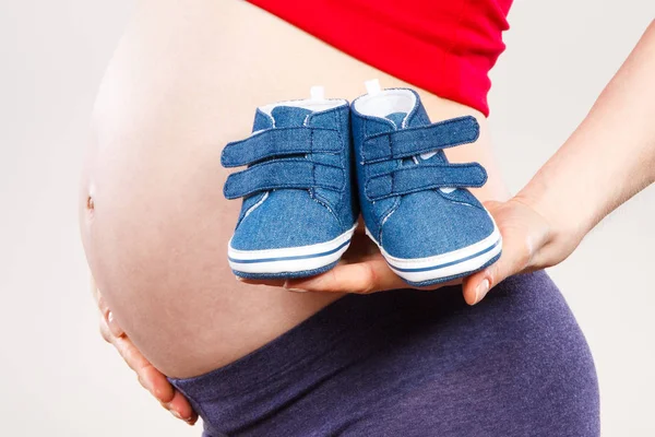Zwangere vrouw met baby schoenen, verwacht voor baby — Stockfoto