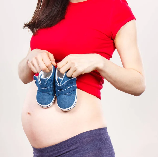 Zwangere vrouw met baby schoenen, verwacht voor baby — Stockfoto