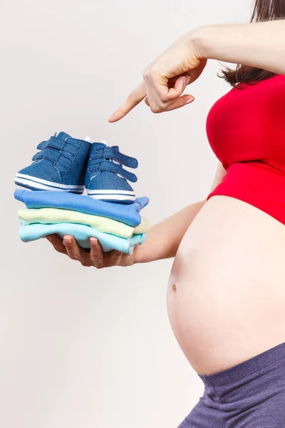 Zwangere vrouw weergegeven: kleding voor pasgeboren, verwacht voor baby — Stockfoto