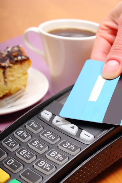 Оплата бесконтактной кредитной картой за чизкейк и кофе в кафе, финансовая концепция — стоковое фото