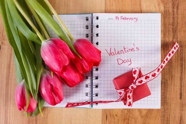 День Святого Валентина, написана в блокноті, свіжі тюльпани і загорнуті подарунок прикраси для Валентина — стокове фото