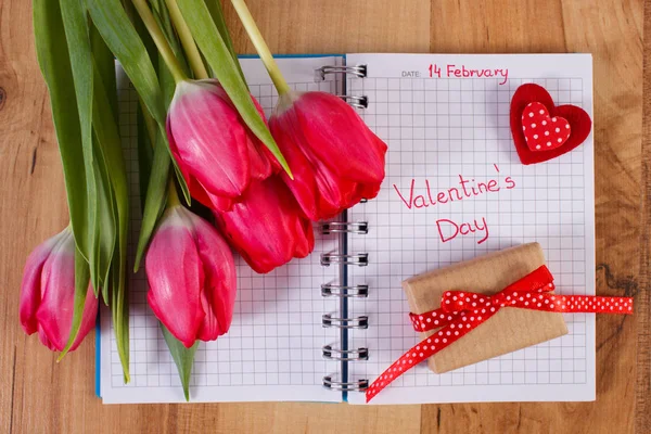 День Святого Валентина, написаний на ноутбук, свіжі тюльпани, загорнуті подарунок і серце, прикраси для Валентина — стокове фото
