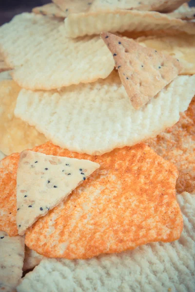 Foto vintage, Montón de patatas fritas saladas y galletas, concepto de comida poco saludable — Foto de Stock