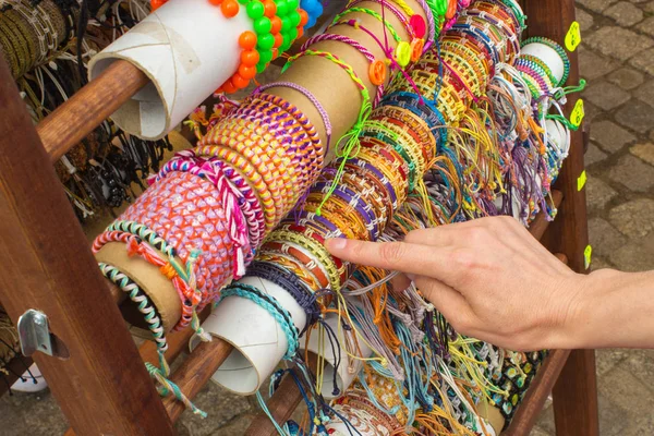 Mão de mulher com pulseiras coloridas na barraca no bazar — Fotografia de Stock