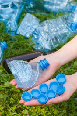 Plastik şişe ve şişe kapakları, kadın ile el çevre çöp