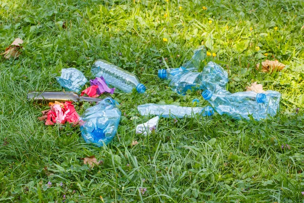 Heap of rubbish on grass in park, littering of environment — Stock Photo, Image