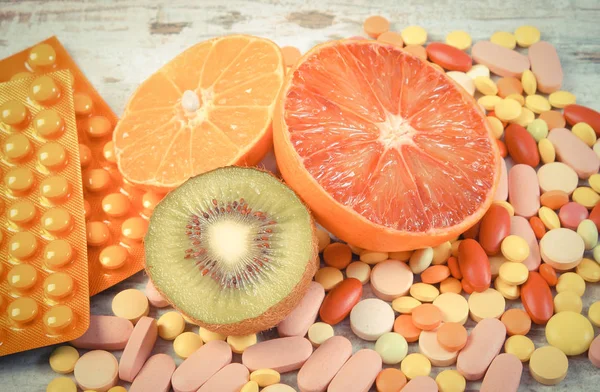 Foto vintage, Frutas naturales y píldoras, elección entre una nutrición saludable y suplementos —  Fotos de Stock