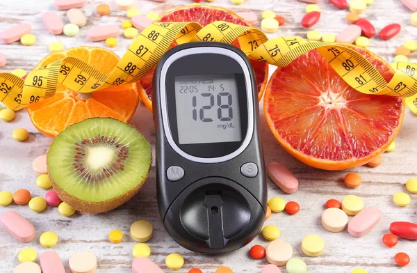 Glucometer con resultado, centímetro, frutas y píldoras médicas, diabetes, adelgazamiento, estilo de vida saludable y nutrición — Foto de Stock