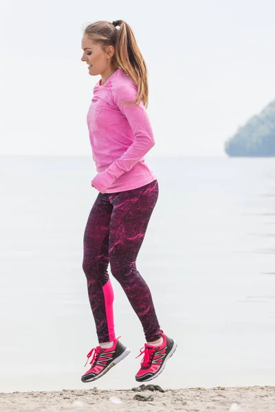 Chica delgada en ropa deportiva haciendo ejercicio en la playa en el mar, estilo de vida activo saludable — Foto de Stock