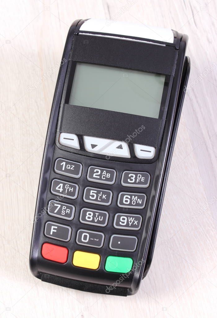 Payment terminal, credit card reader on wooden background, cashless paying for shopping, finance concept
