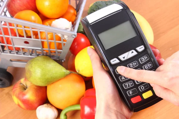 Using payment terminal, fruits and vegetables, cashless paying for shopping, enter personal identification number — Stock Photo, Image