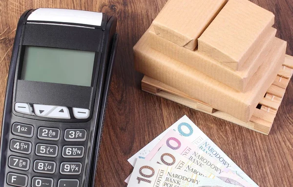 Terminal de pagamento, dinheiro em moeda polonesa e caixas embrulhadas em paletes de madeira — Fotografia de Stock