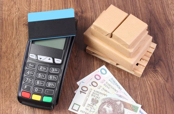 Terminal de pago con tarjeta de crédito, dinero de moneda polaca y cajas envueltas en paleta de madera — Foto de Stock