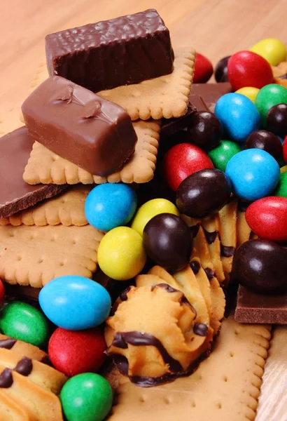 Una gran cantidad de dulces en la superficie de madera, alimentos poco saludables —  Fotos de Stock