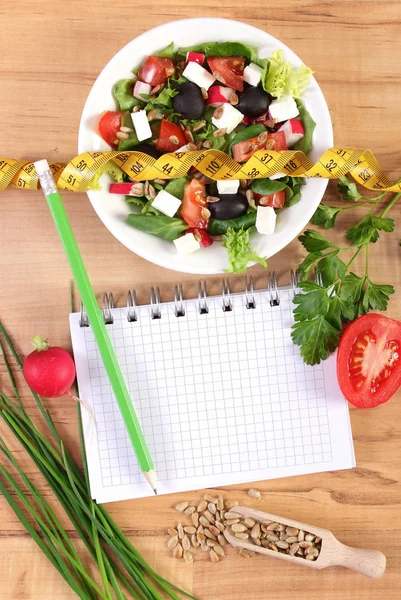 Свежий греческий салат с овощами, сантиметр и блокнот для записи заметок, здорового питания и похудения — стоковое фото