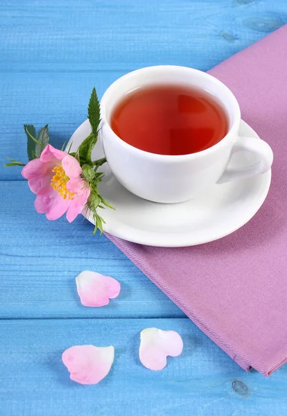 Kopje thee en wild rose bloem op de blauwe borden — Stockfoto