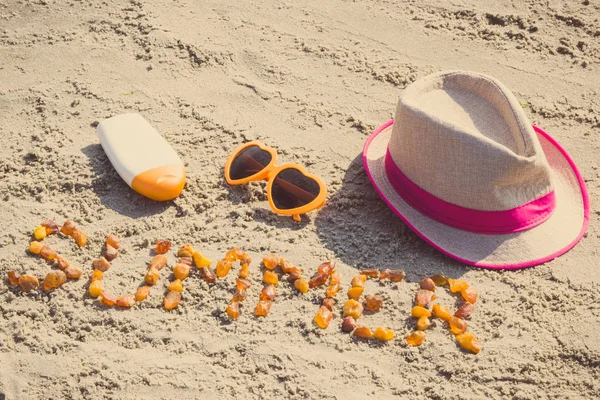 Foto vintage, Word verano, gafas de sol, loción solar y sombrero de paja en la arena en la playa, hora de verano —  Fotos de Stock