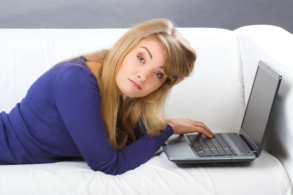 Mulher preocupada com laptop deitado no sofá, tecnologia moderna — Fotografia de Stock
