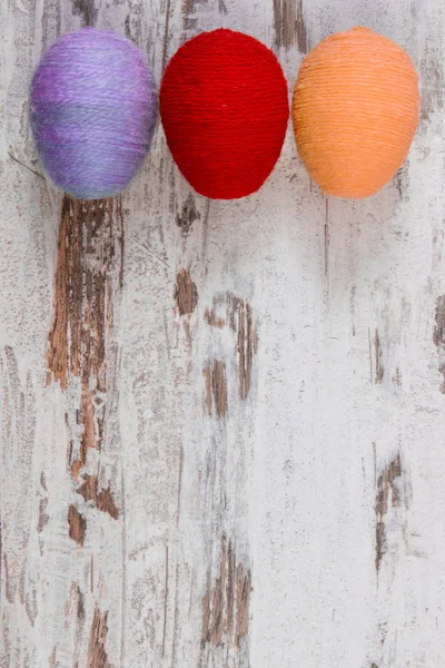 Easter eggs wrapped woolen string on wooden background, copy space for text, decoration for Easter — Stock Photo, Image