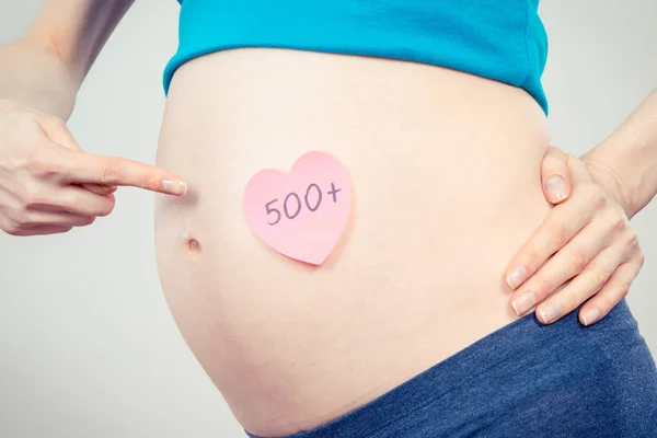 Gravid kvinna visar inskriptionen 500 +, sociala program och politik i Polen — Stockfoto