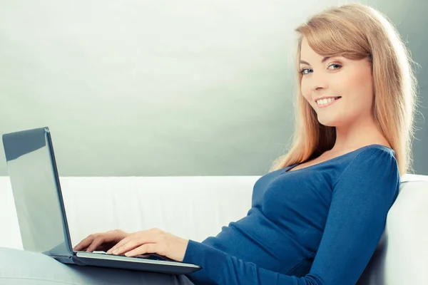 Винтажное фото, Счастливая женщина с ноутбуком, сидящая на диване, современные технологии — стоковое фото