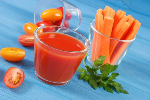Tomatensap en groenten op een blauw bord, gezonde voeding — Stockfoto